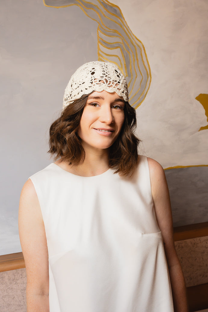 Lächelnde Braut mit gehäkelter Boho-Cap AOLANI und Blumenmuster von MOANA