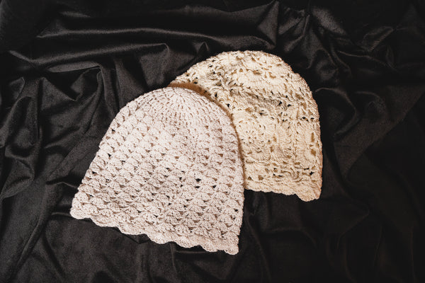 Zwei gehäkelte Boho-Caps im Vergleich: AOLANI mit Blumenmuster und HONU mit Muschelmuster