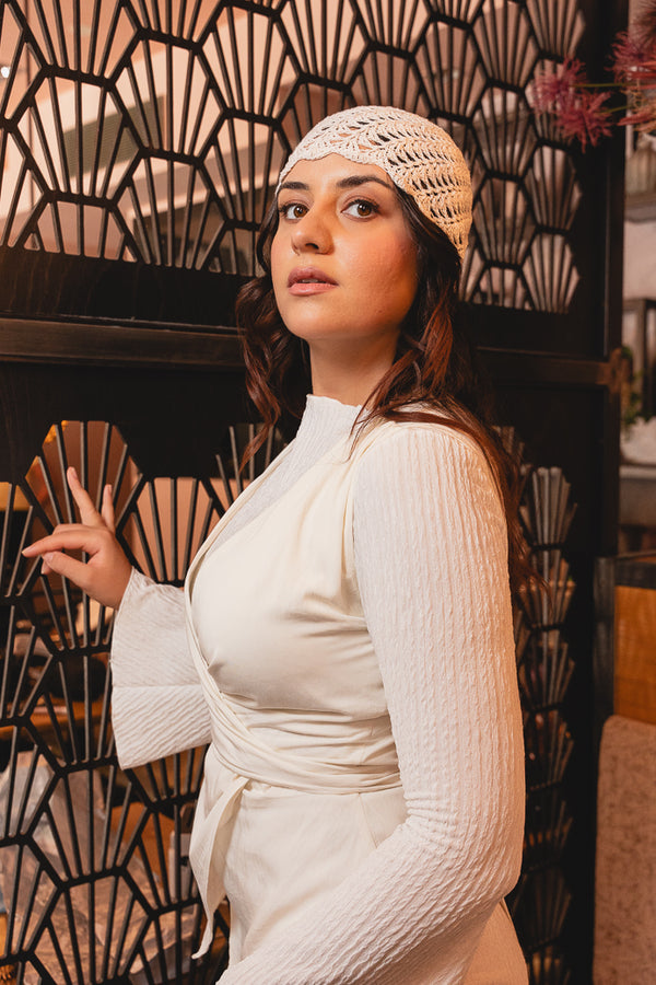 Seitliches Portrait der Braut mit gehäkeltem Boho-Brautkopfschmuck Brautcap HONU vor Art-déco-Wand